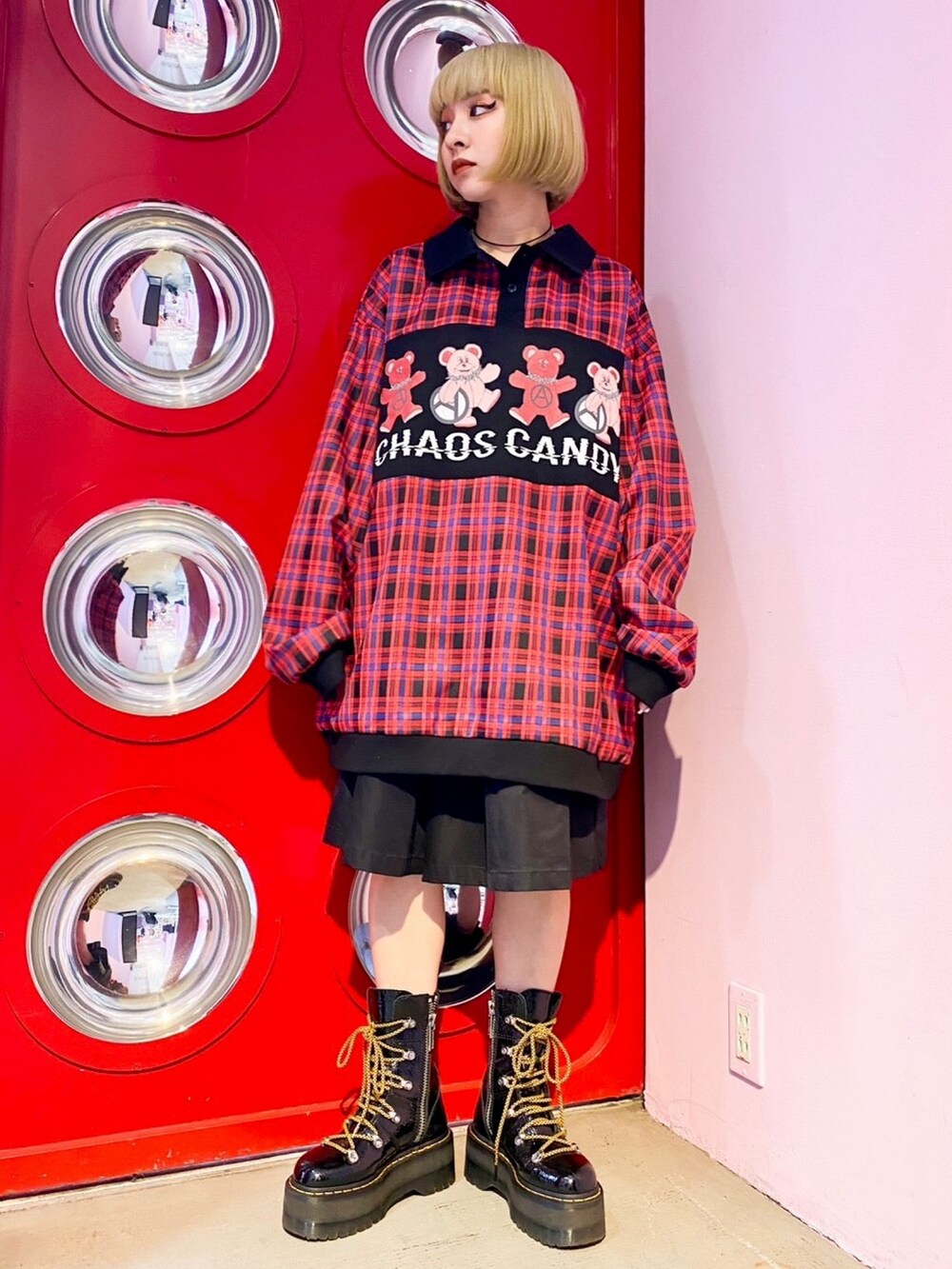 ブラック系のシューズ、ブラック系のスカート、レッド系のポロシャツを着用したレディースの春コーディネートの2枚目の写真