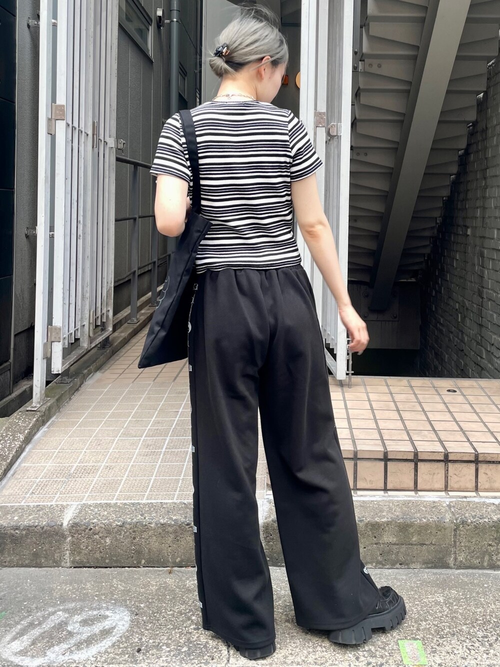 ブラック系のTシャツ/カットソー、ブラック系のその他パンツ、ブラック系のトートバッグを着用したレディースの夏コーディネートの4枚目の写真