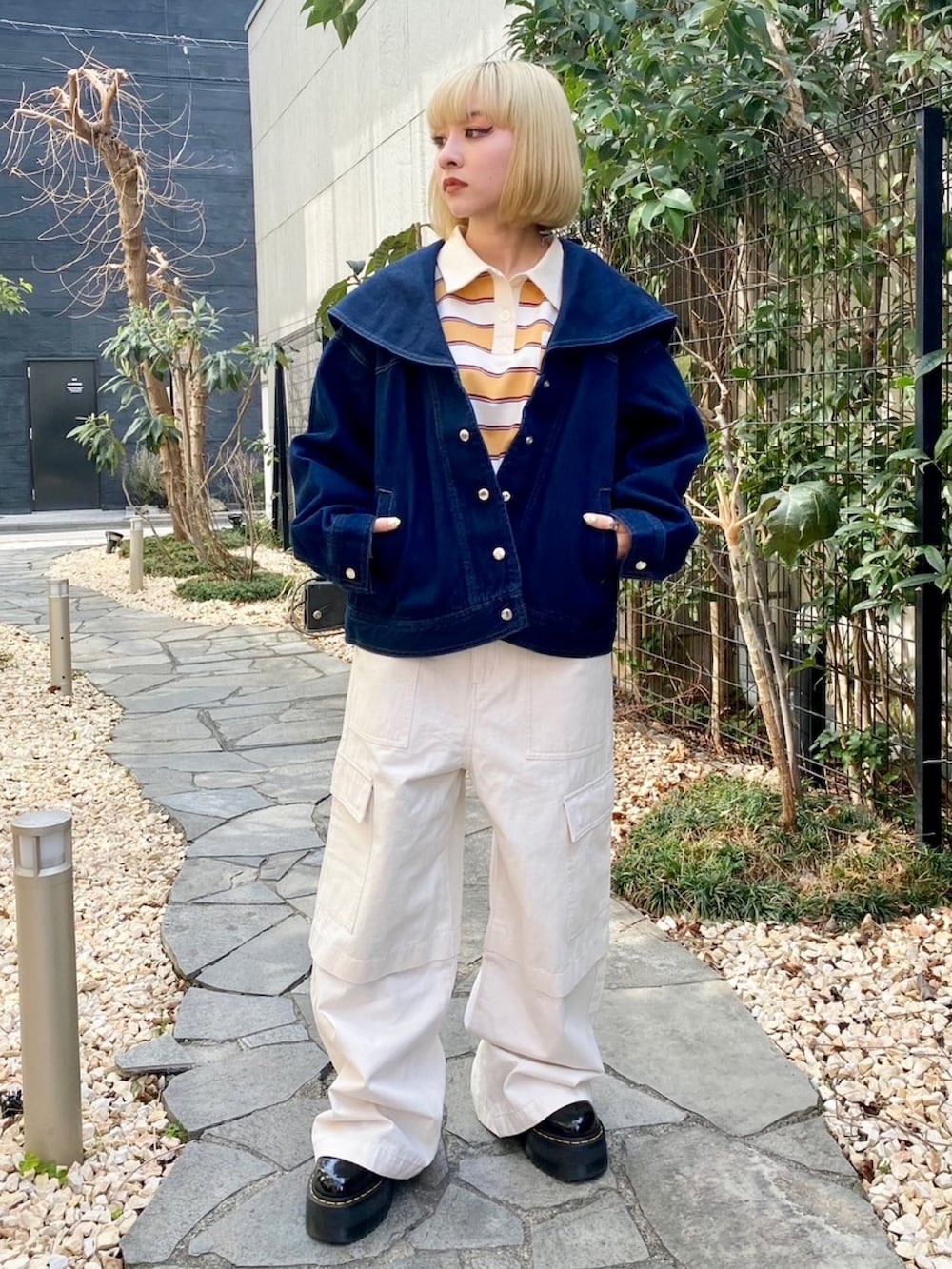 ホワイト系のカーゴパンツ、イエロー系のポロシャツ、ブルー系のデニムジャケットを着用したレディースの春コーディネートの2枚目の写真