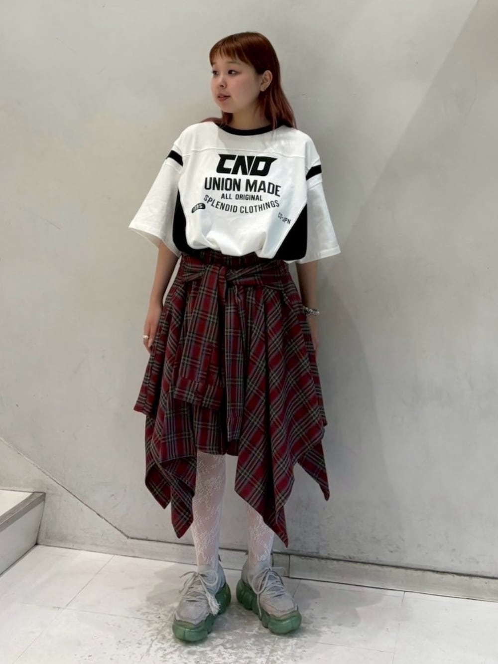 ホワイト系のワンピース、レッド系のスカートを着用したレディースの秋コーディネートの2枚目の写真