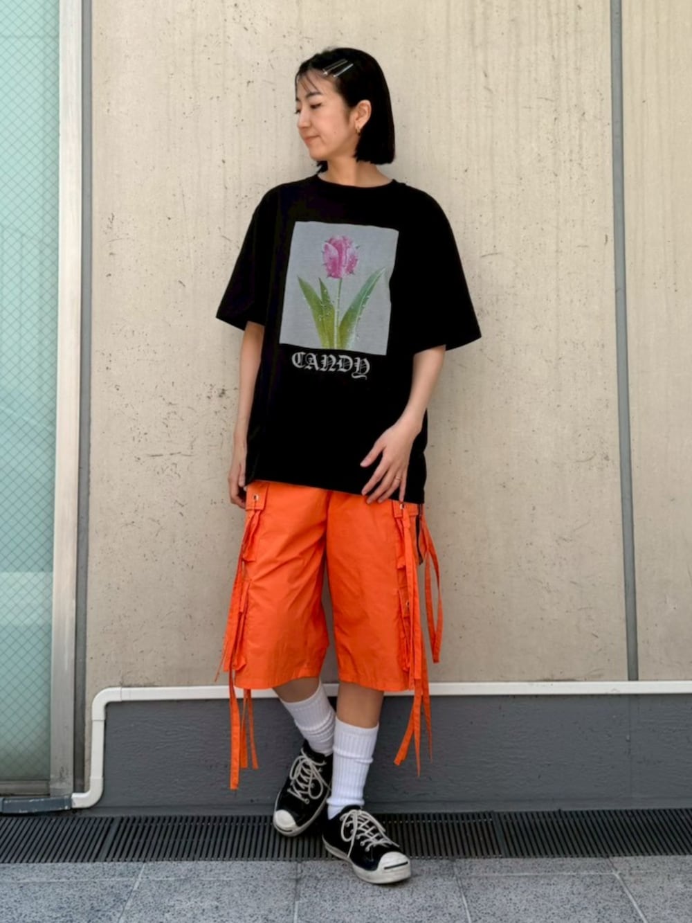 ブラック系のTシャツ/カットソー、オレンジ系のその他パンツを着用したレディースの春コーディネートの2枚目の写真