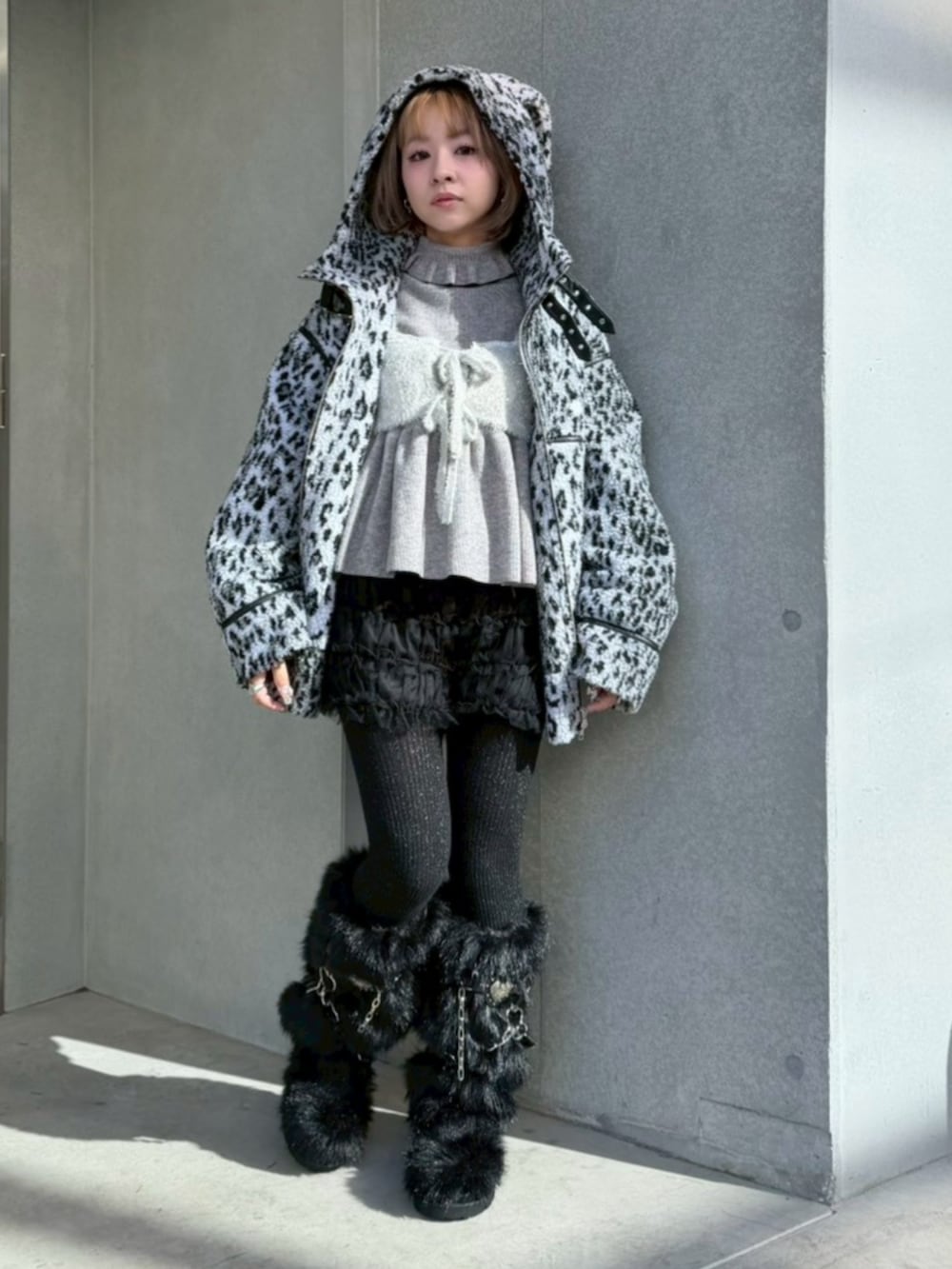 ブラック系のその他パンツ、グレー系のダウンジャケット/コート、グレー系のニット/セーターを着用したレディースの冬コーディネートの2枚目の写真