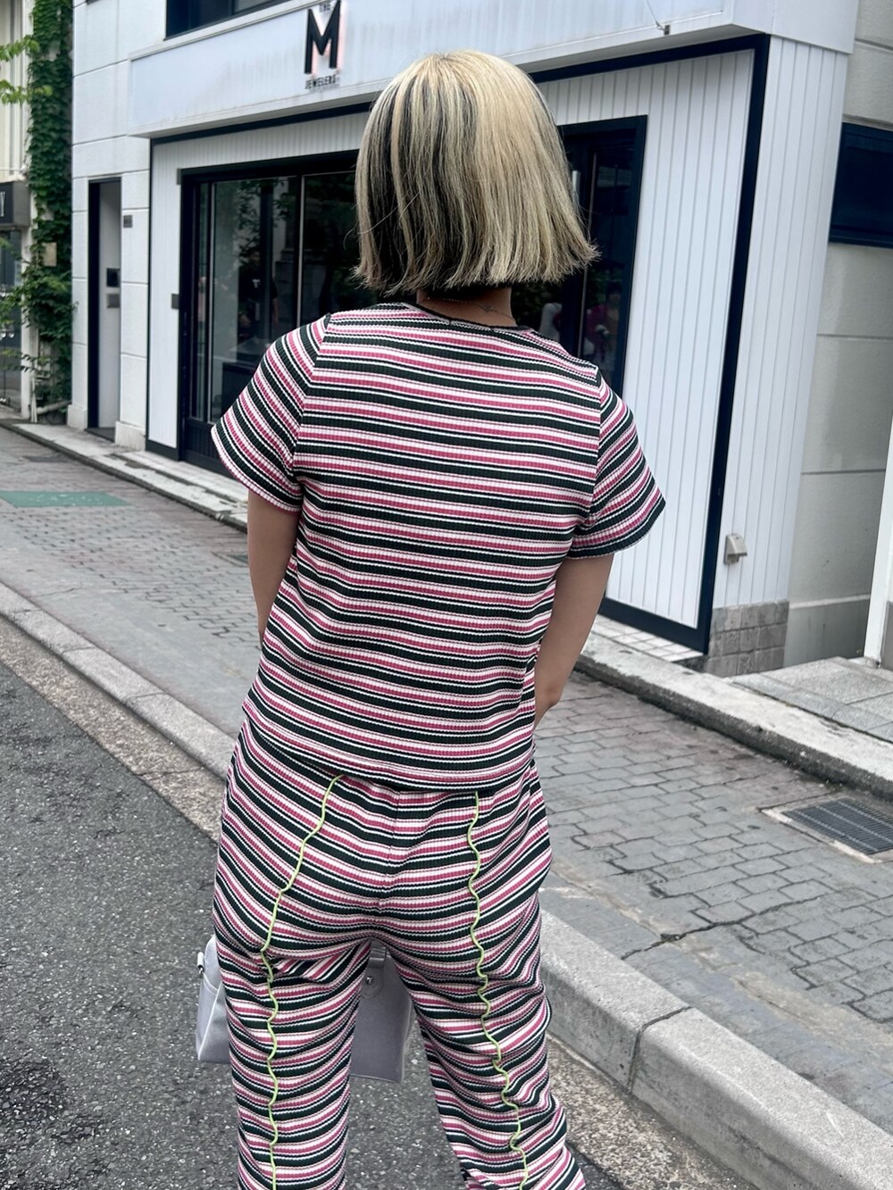 グリーン系のTシャツ/カットソー、グリーン系のその他パンツ、シルバー系のボストンバッグを着用したレディースの夏コーディネートの3枚目の写真