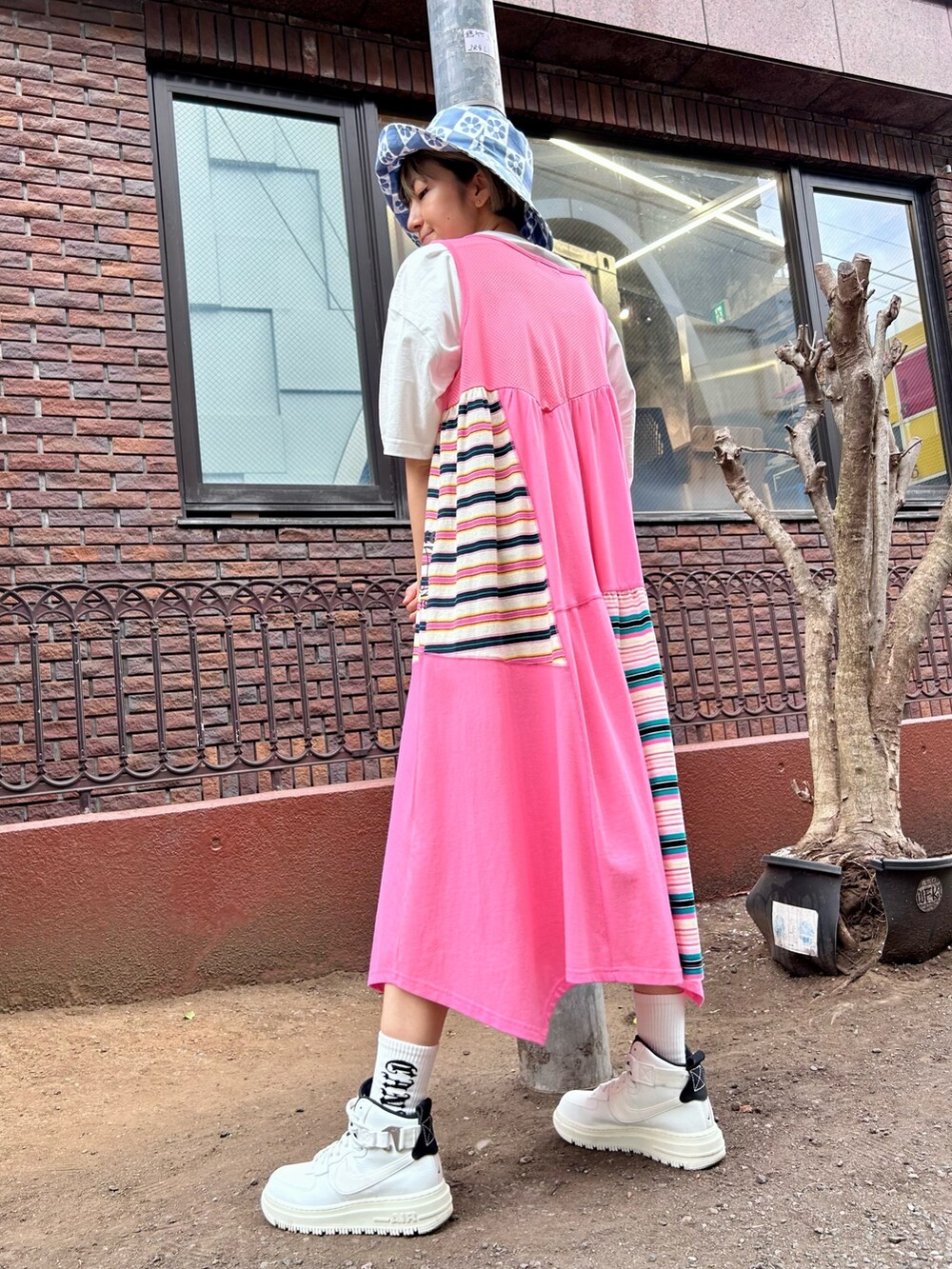 ピンク系のワンピース、ホワイト系のTシャツ/カットソー、ブルー系のハットを着用したレディースの春コーディネートの3枚目の写真