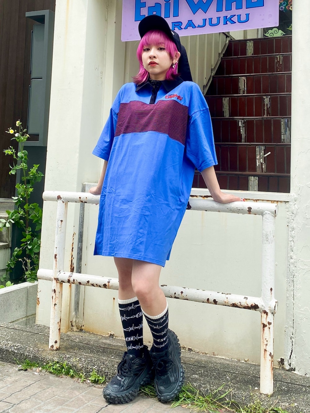 ブルー系のワンピース、ブラック系のボストンバッグ、ブラック系のキャップを着用したレディースの春コーディネートの2枚目の写真