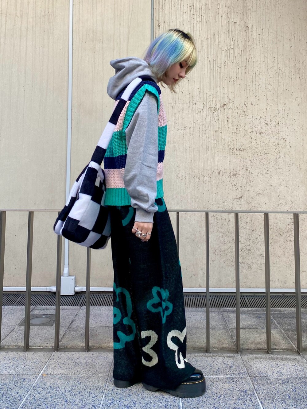 グレー系のパーカー、グリーン系のベスト、ブラック系のその他パンツを着用したレディースの冬コーディネートの2枚目の写真