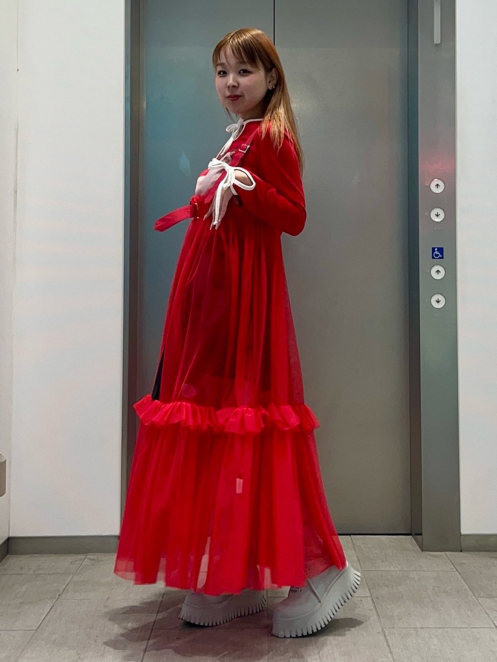 レッド系のスカート、ブラック系のその他パンツ、レッド系のTシャツ/カットソーを着用したレディースの冬コーディネートの3枚目の写真