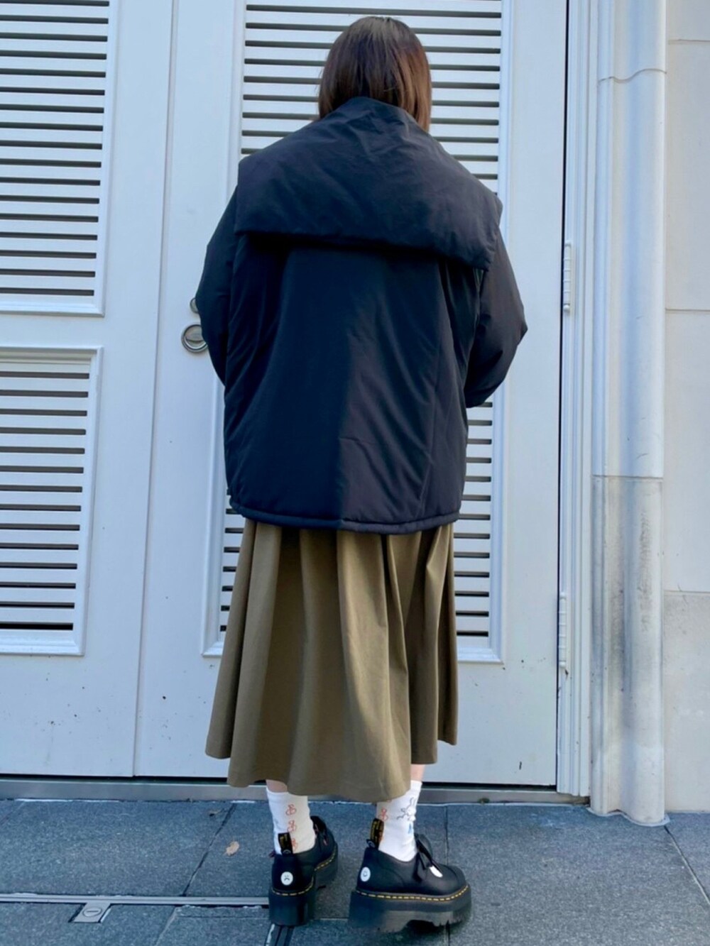 ブラック系のその他アウター、グリーン系のワンピース、ブラック系のシューズを着用したレディースの秋コーディネートの3枚目の写真