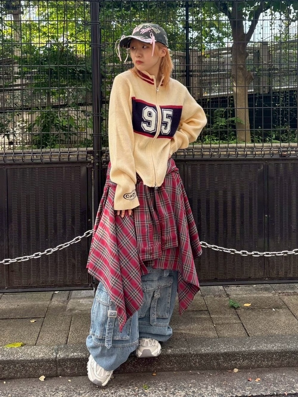 ブルー系のデニムパンツ、レッド系のスカート、ホワイト系のニット/セーターを着用したレディースの秋コーディネートの3枚目の写真