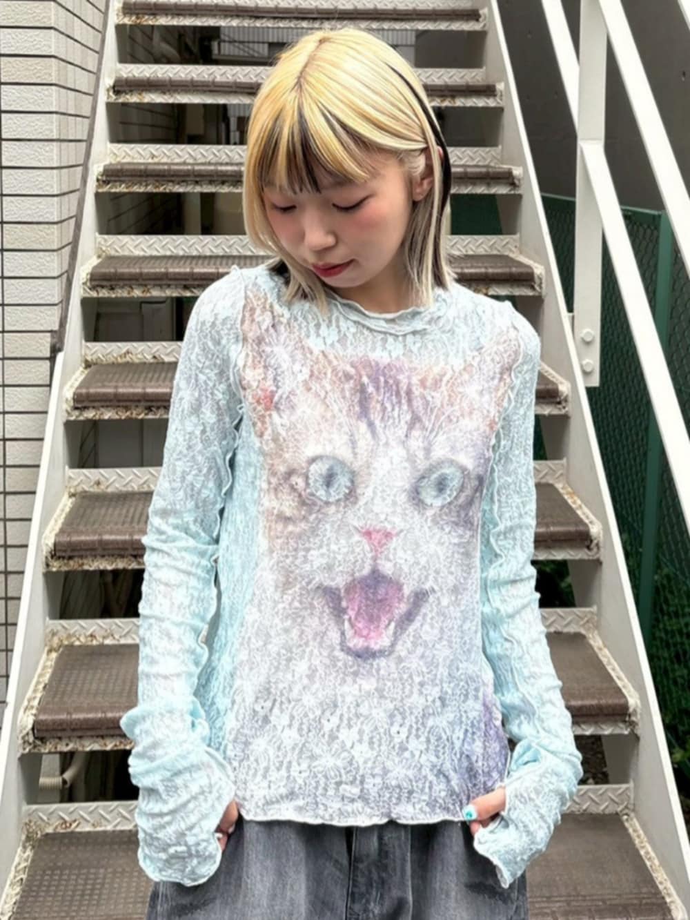 ブラック系のデニムパンツ、ブルー系のTシャツ/カットソー、ホワイト系のスニーカーを着用したレディースの夏コーディネートの3枚目の写真