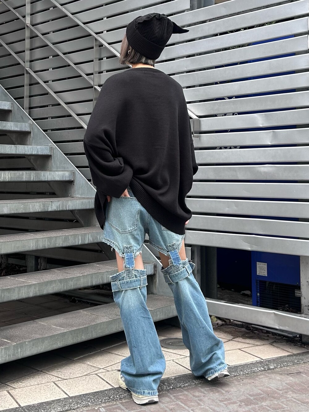 ブラック系のニット/セーター、ブルー系のデニムパンツ、シルバー系のシューズを着用したレディースの秋コーディネートの5枚目の写真