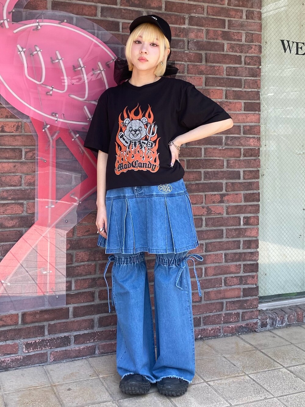 ブルー系のスカート、ブラック系のTシャツ/カットソー、ブラック系のキャップを着用したレディースの春コーディネートの2枚目の写真