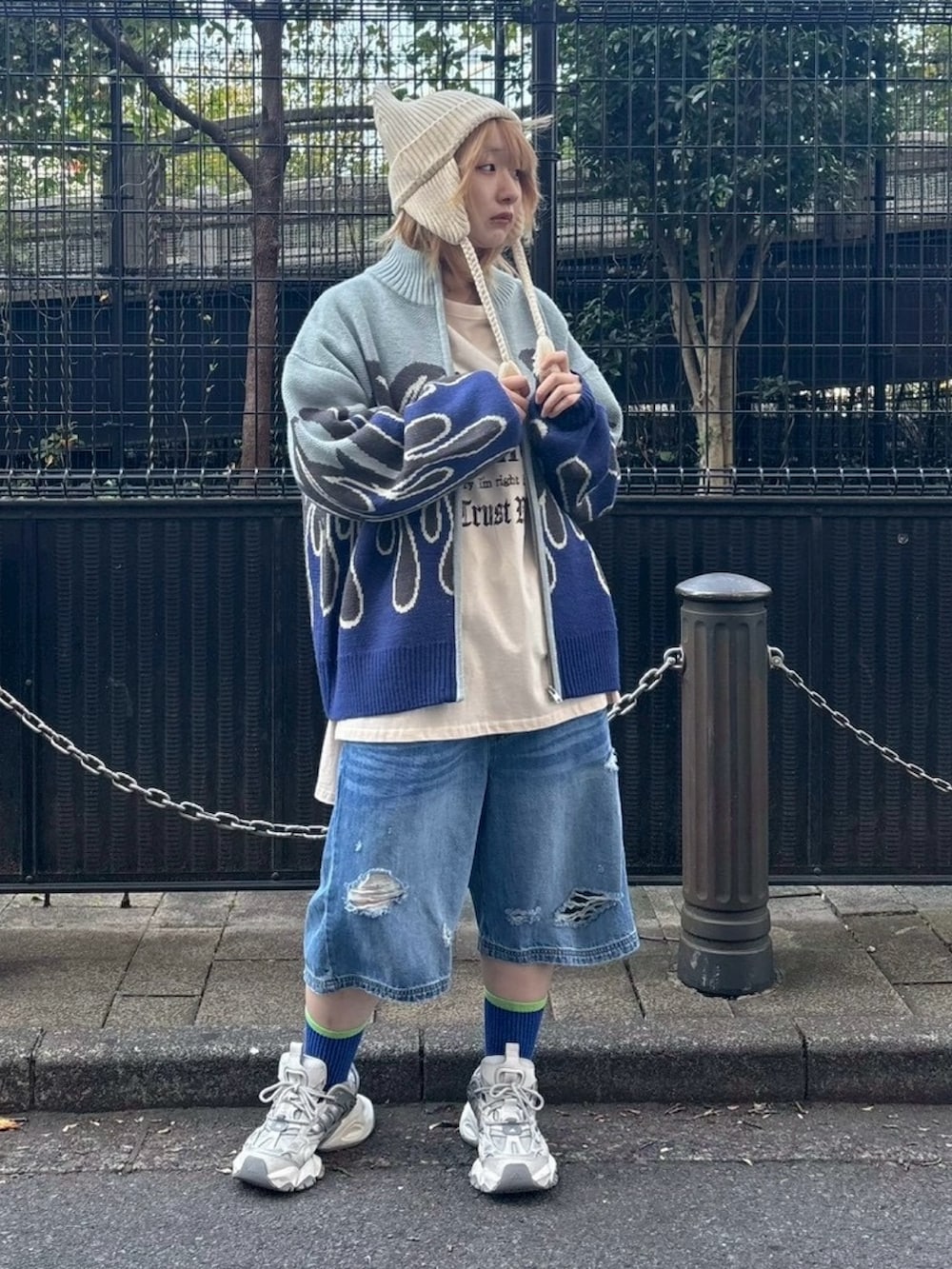 ブルー系のニット/セーター、ベージュ系のTシャツ/カットソー、ブルー系のデニムパンツを着用したレディースの秋コーディネートの3枚目の写真