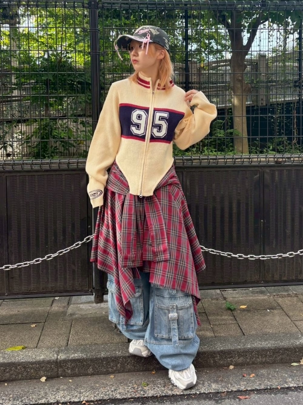 ブルー系のデニムパンツ、レッド系のスカート、ホワイト系のニット/セーターを着用したレディースの秋コーディネートの2枚目の写真