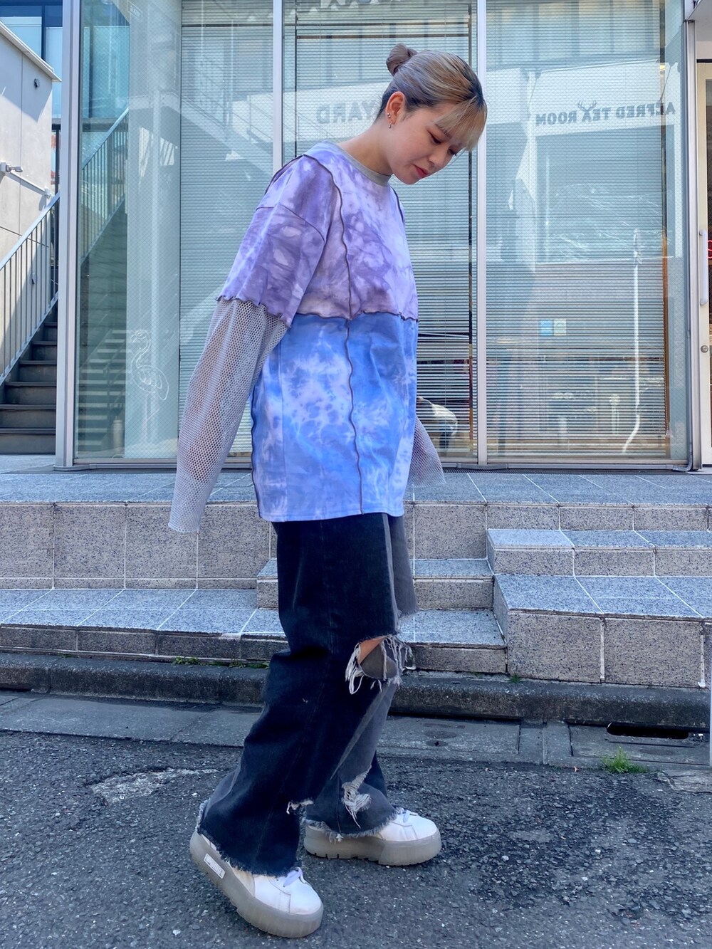 ブラック系のデニムパンツ、パープル系のTシャツ/カットソーを着用したレディースの春コーディネートの2枚目の写真