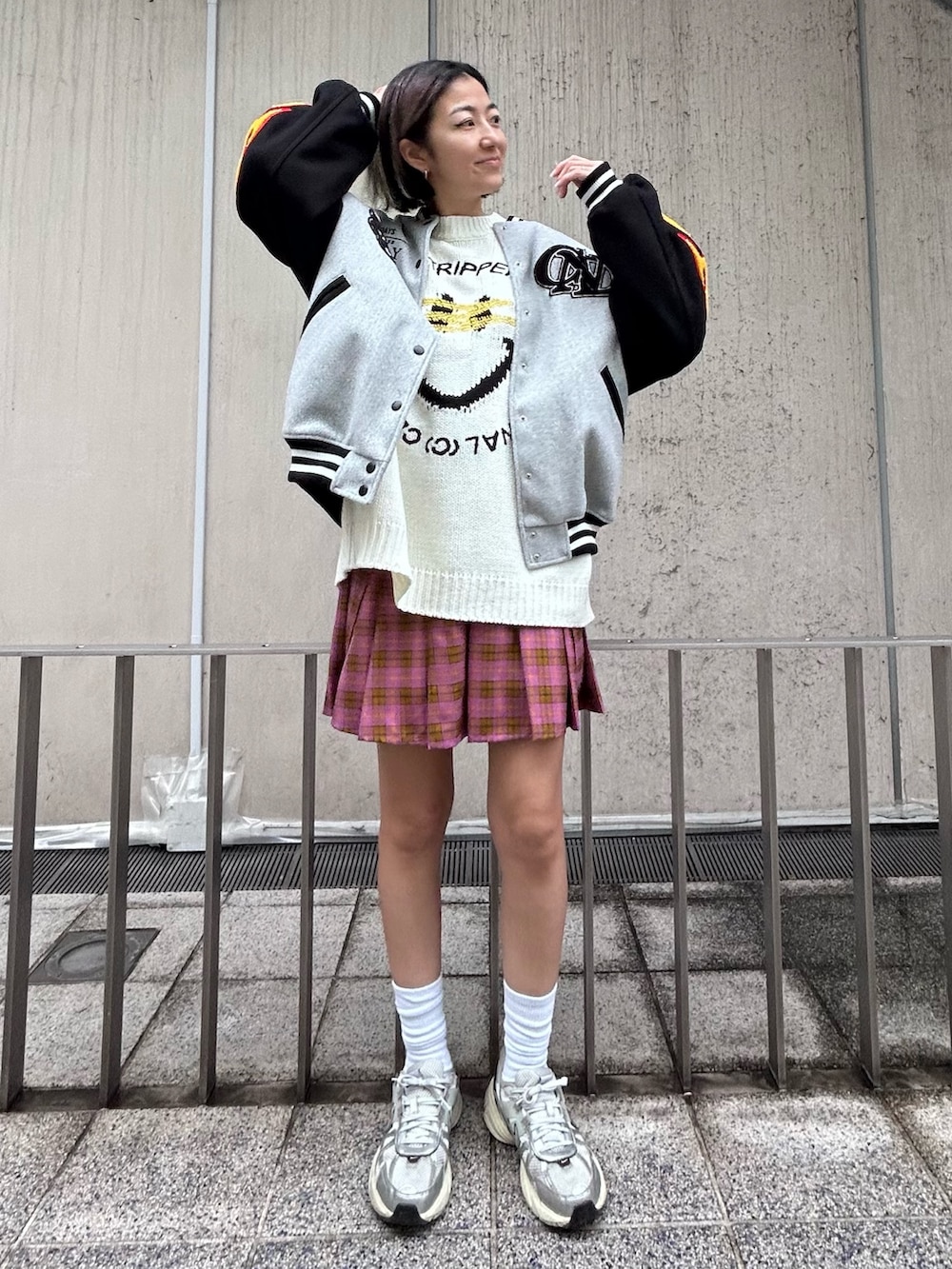 シルバー系のシューズ、ピンク系のスカート、ホワイト系のニット/セーターを着用したレディースの秋コーディネートの3枚目の写真