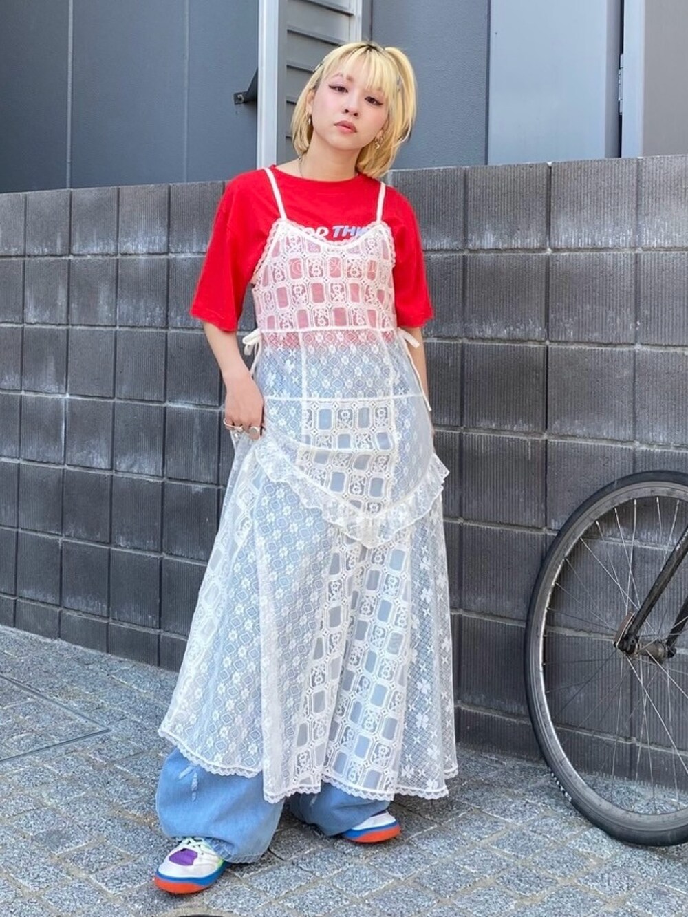 ブルー系のデニムパンツ、ホワイト系のワンピース、レッド系のTシャツ/カットソーを着用したレディースの夏コーディネートの3枚目の写真