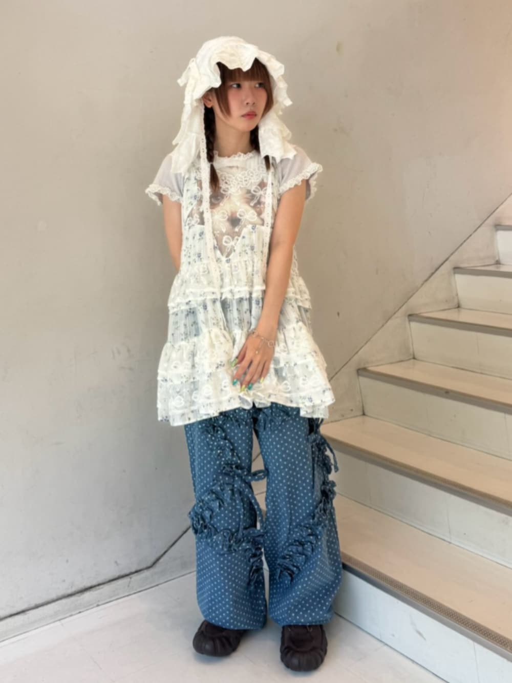 グレー系のTシャツ/カットソー、ブルー系のデニムパンツ、ホワイト系のワンピースを着用したレディースの秋コーディネートの2枚目の写真