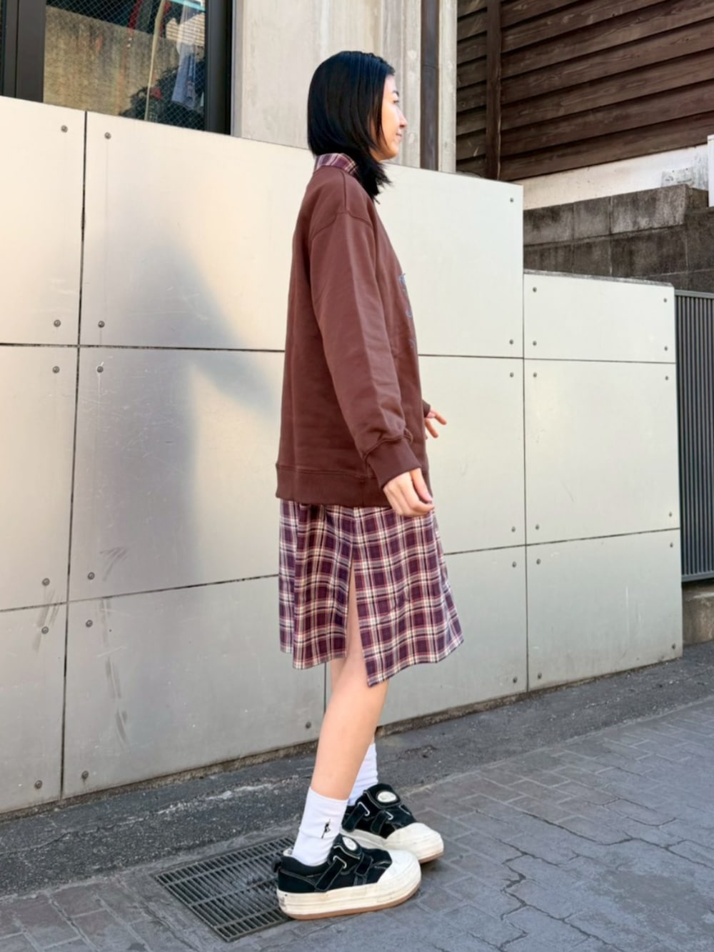 パープル系のシャツワンピース、ブラウン系のスウェットを着用したレディースの冬コーディネートの2枚目の写真