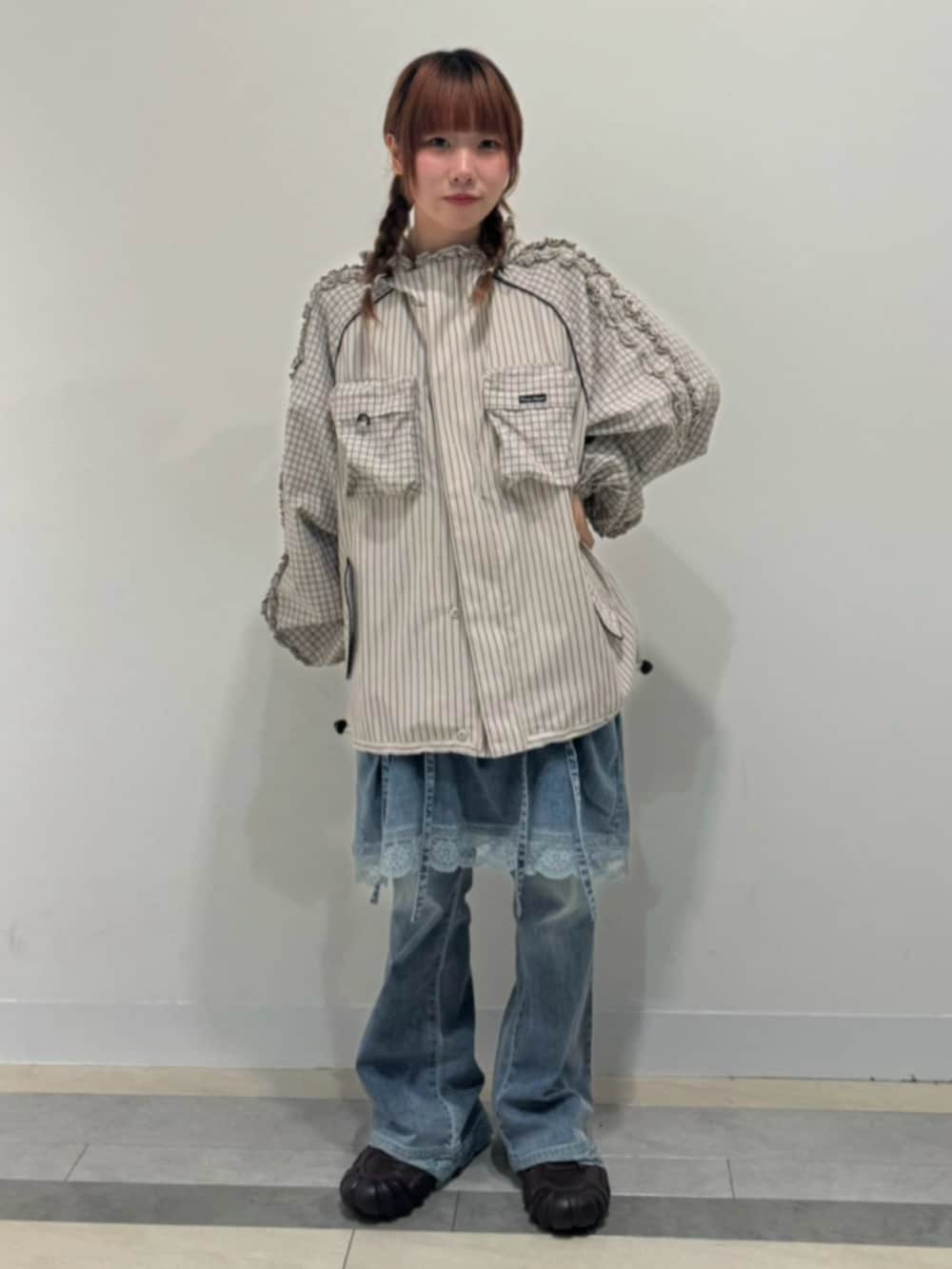 ベージュ系のブルゾン、ブルー系のデニムパンツを着用したレディースの秋コーディネートの2枚目の写真