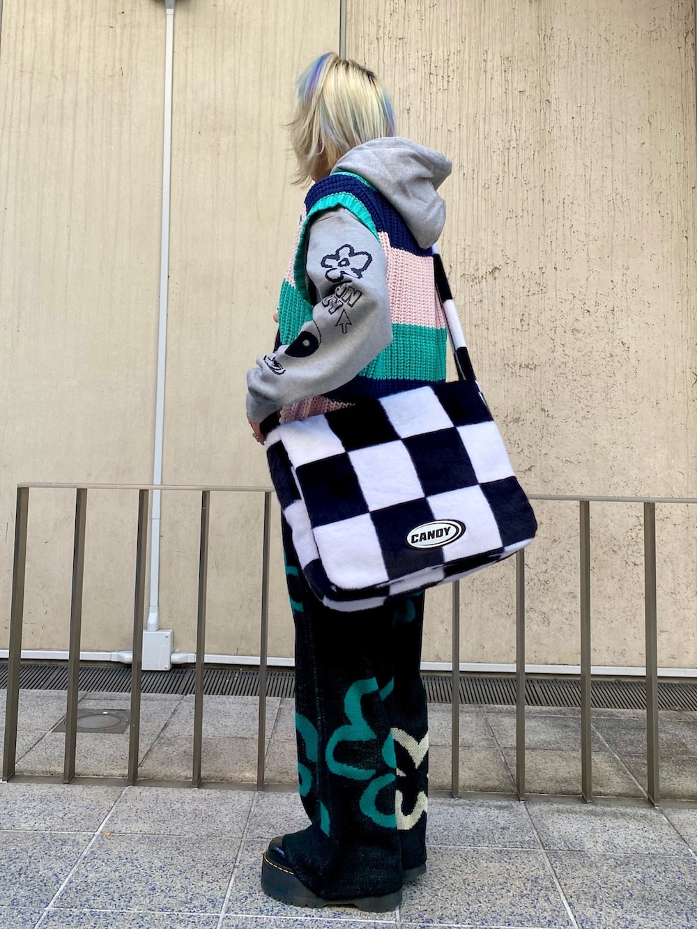 グレー系のパーカー、グリーン系のベスト、ブラック系のその他パンツを着用したレディースの冬コーディネートの3枚目の写真