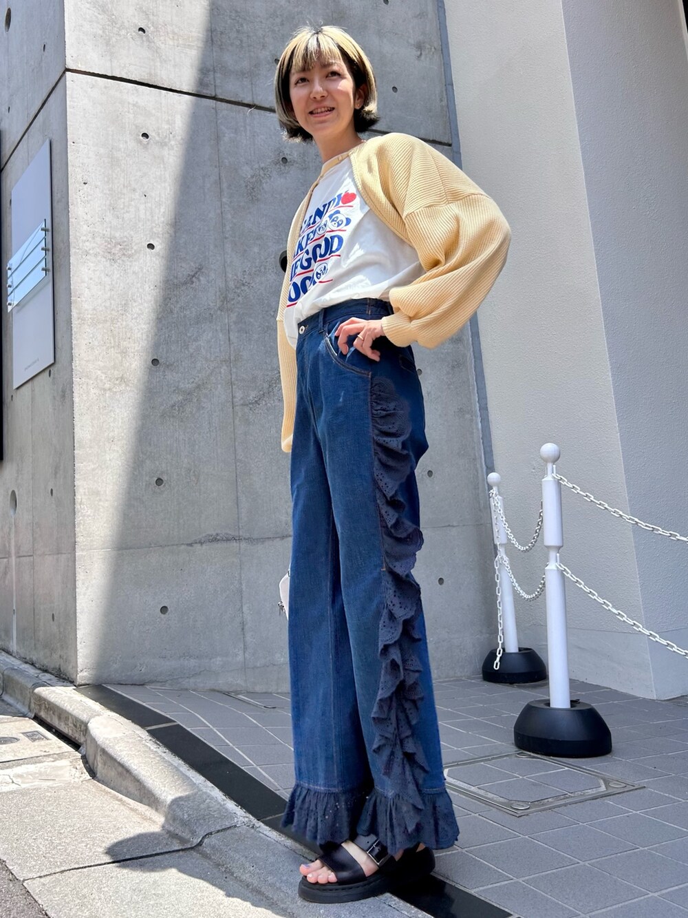 イエロー系のカーディガン/ボレロ、ホワイト系のTシャツ/カットソー、シルバー系のボストンバッグを着用したレディースの夏コーディネートの2枚目の写真