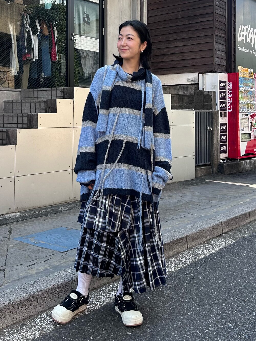 ブルー系のスカート、グレー系のニット/セーターを着用したレディースの秋コーディネートの4枚目の写真