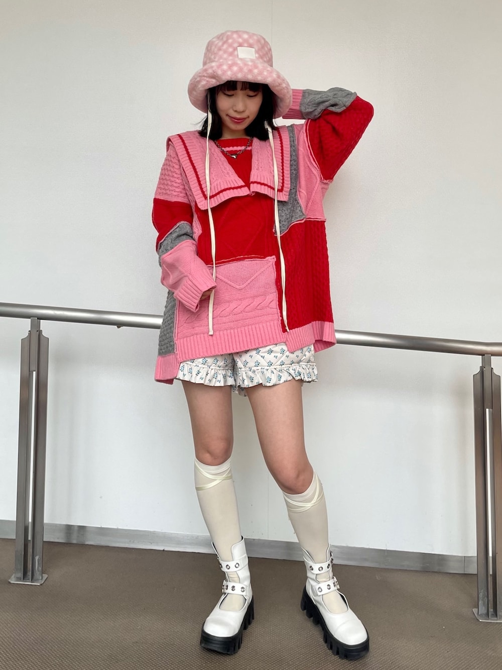 ピンク系のニット/セーター、ホワイト系のその他パンツ、ホワイト系のブーツを着用したレディースの秋コーディネートの2枚目の写真