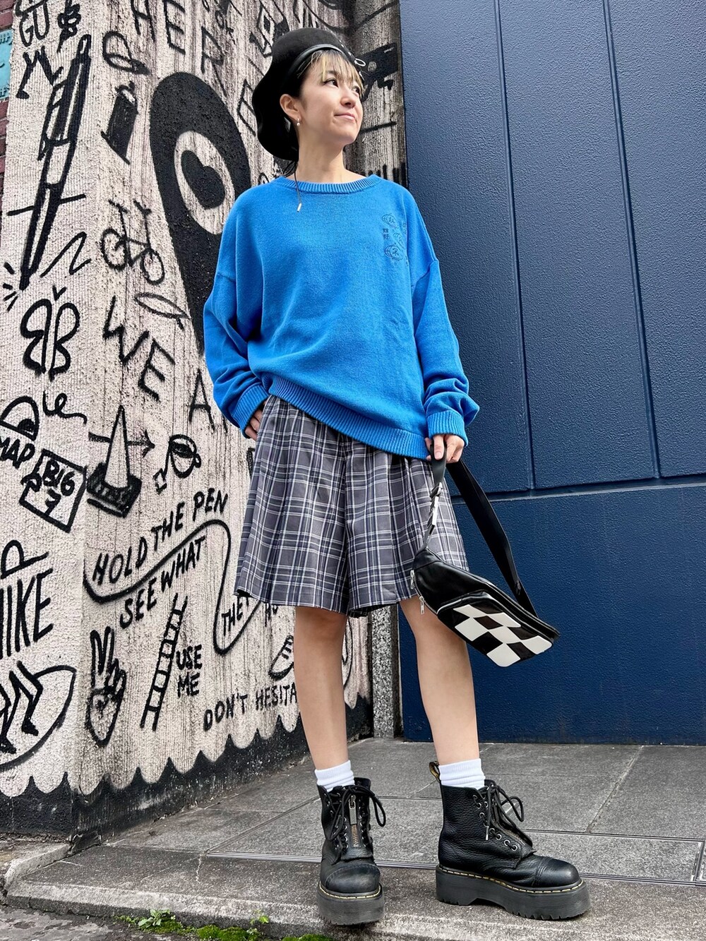 ブルー系のニット/セーター、グレー系のスカート、ブラック系のボディバッグ/ウエストポーチを着用したレディースの秋コーディネートの2枚目の写真