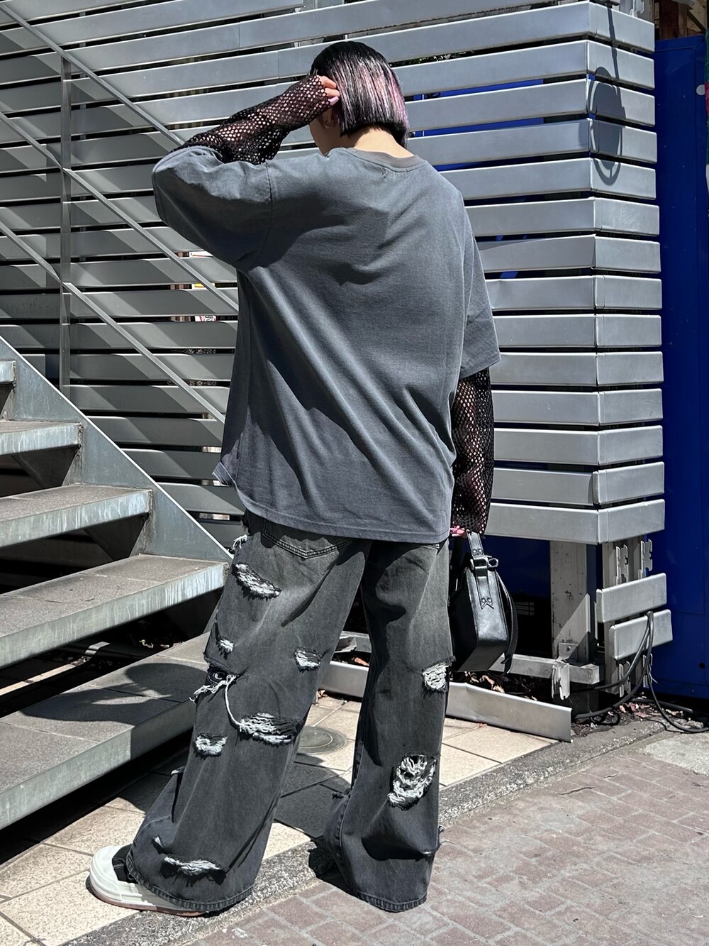 ブラック系のショルダーバッグ、ブラック系のデニムパンツ、グレー系のTシャツ/カットソーを着用したレディースの春コーディネートの4枚目の写真