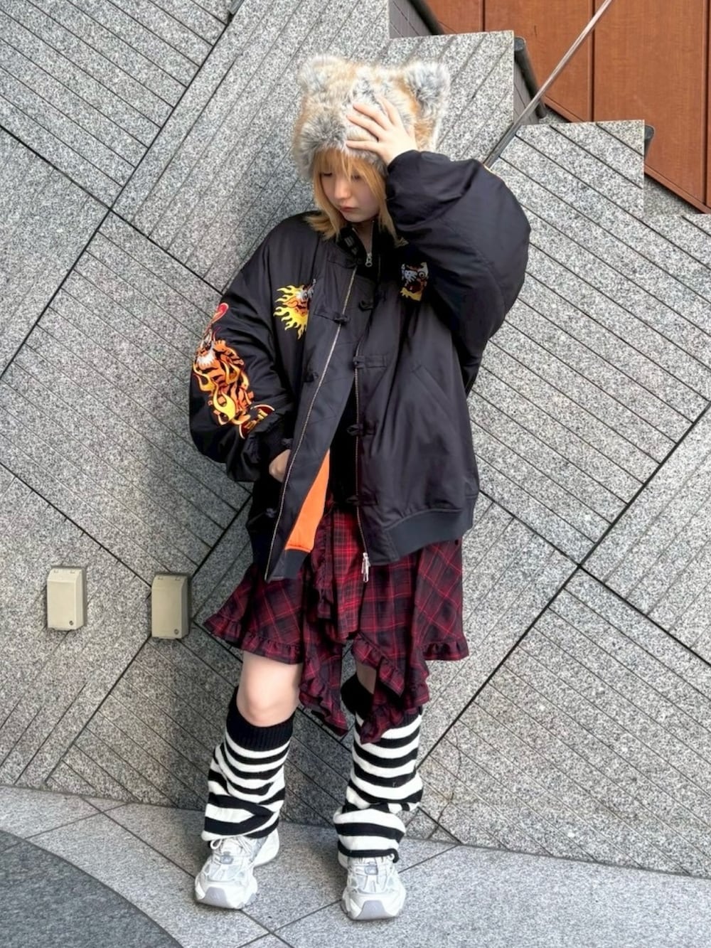 レッド系のワンピース、ブラック系のニット/セーター、ブラック系のMA-1を着用したレディースの秋コーディネートの3枚目の写真