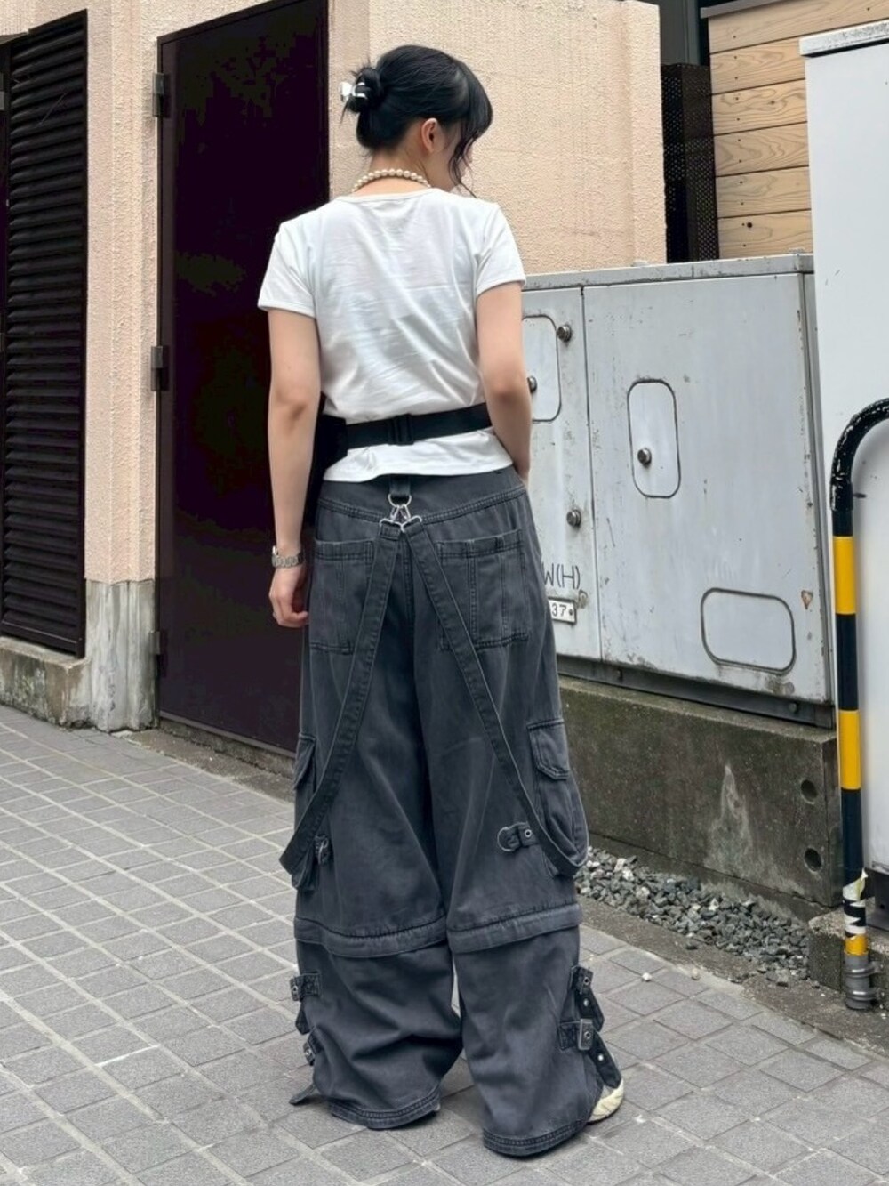 ブラック系のボディバッグ/ウエストポーチ、ブラック系のデニムパンツ、ホワイト系のTシャツ/カットソーを着用したレディースの夏コーディネートの3枚目の写真