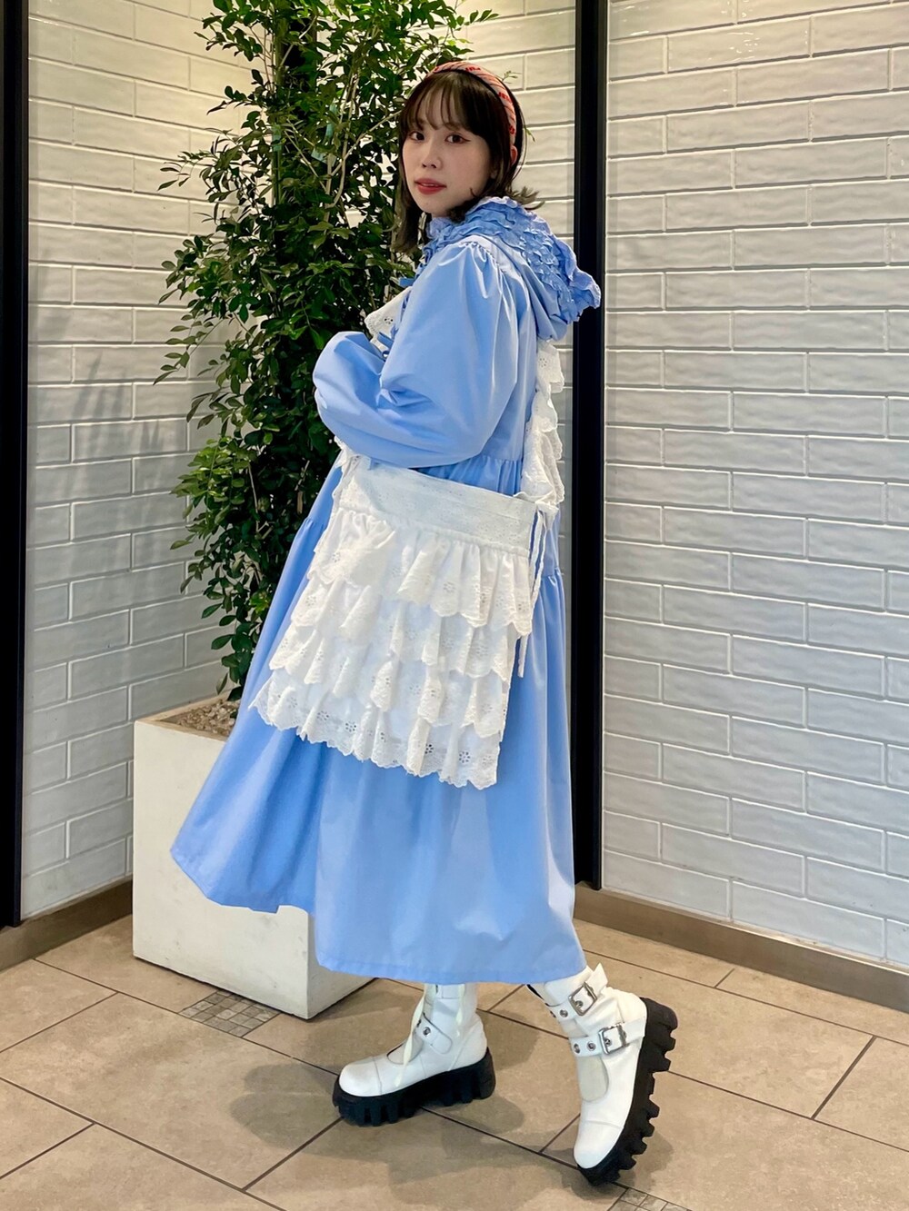 ブルー系のワンピース、ホワイト系のショルダーバッグ、ホワイト系のブーツを着用したレディースの冬コーディネートの4枚目の写真