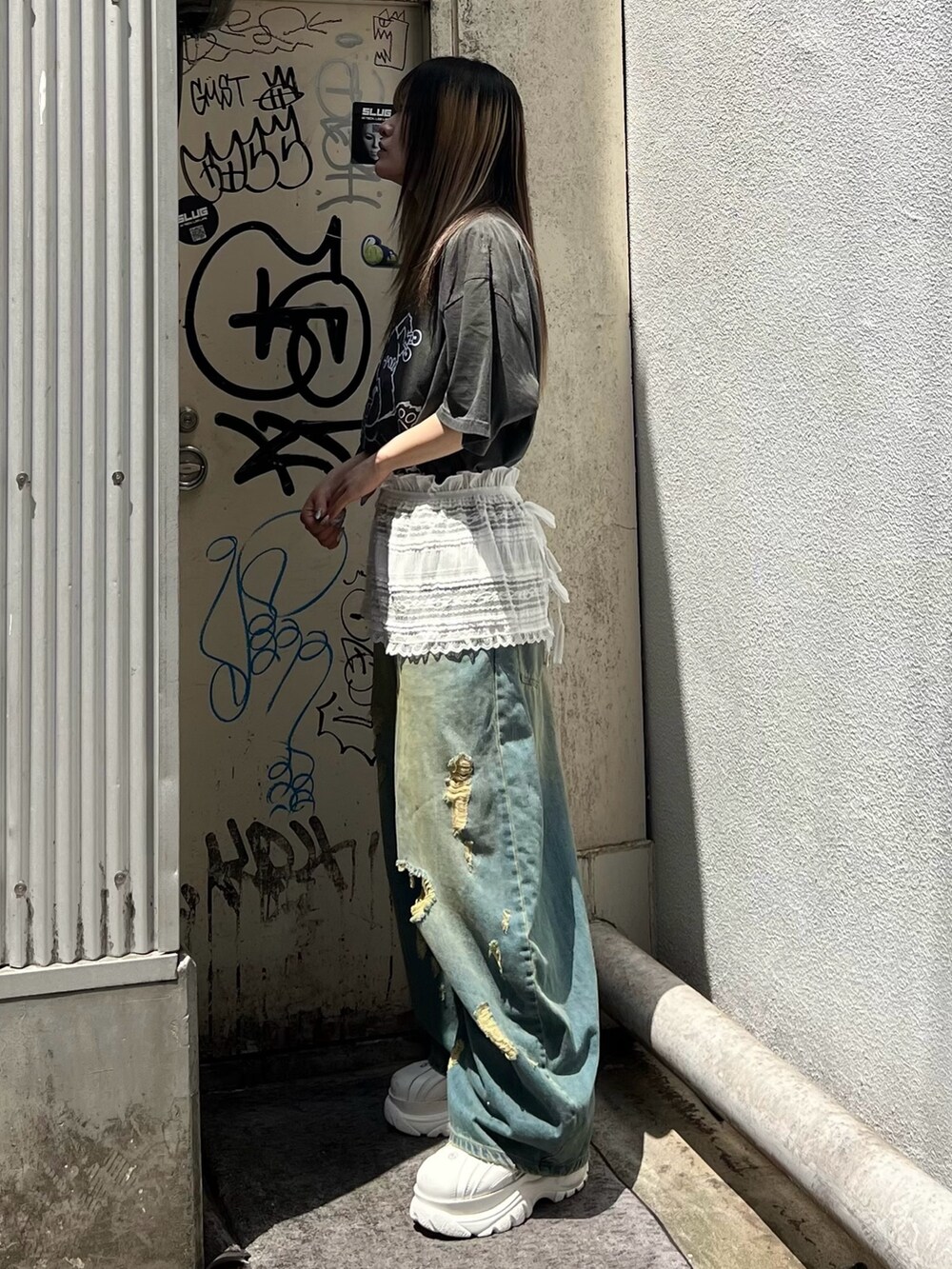 グレー系のTシャツ/カットソー、ホワイト系のスカート、ブルー系のデニムパンツを着用したレディースの夏コーディネートの2枚目の写真