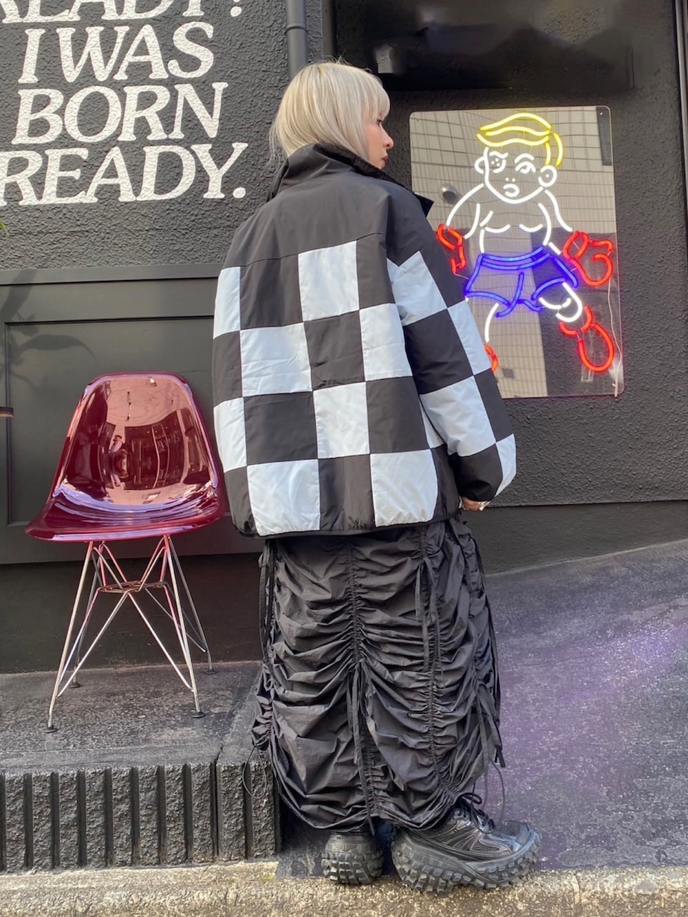 ブラック系のスカート、ブラック系のダウンジャケット/コート、ブラック系のTシャツ/カットソーを着用したレディースの秋コーディネートの4枚目の写真