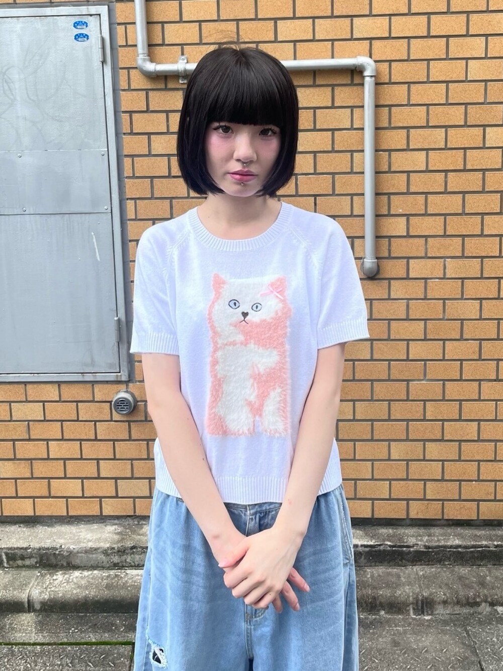 ブルー系のデニムパンツ、ホワイト系のニット/セーターを着用したレディースの夏コーディネートの4枚目の写真