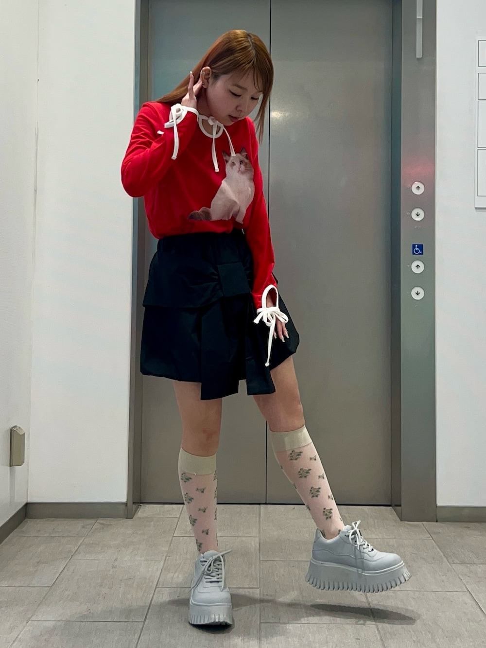 レッド系のスカート、ブラック系のその他パンツ、レッド系のTシャツ/カットソーを着用したレディースの冬コーディネートの6枚目の写真