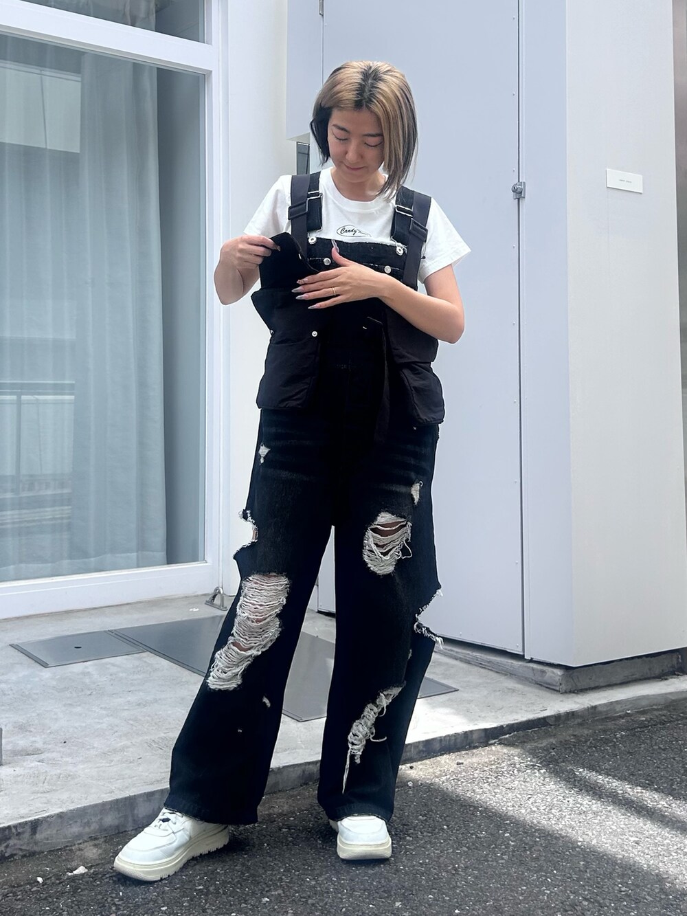 ホワイト系のTシャツ/カットソー、ブラック系のサロペット/オーバーオール、ブラック系のベストを着用したレディースの夏コーディネートの3枚目の写真