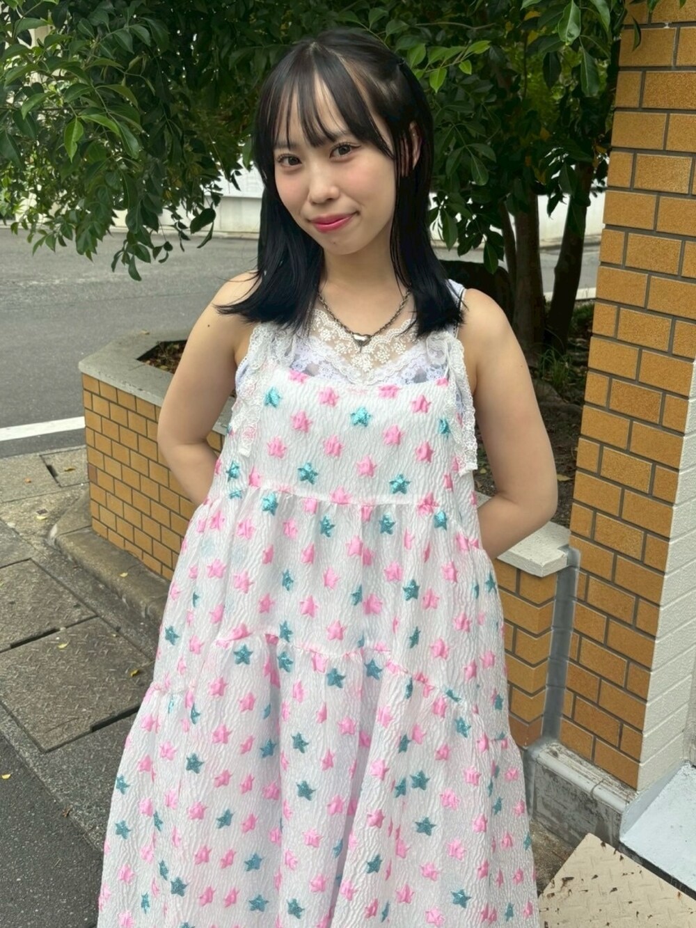 ピンク系のワンピース、ホワイト系のキャミソール、ブルー系のデニムパンツを着用したレディースの夏コーディネートの6枚目の写真