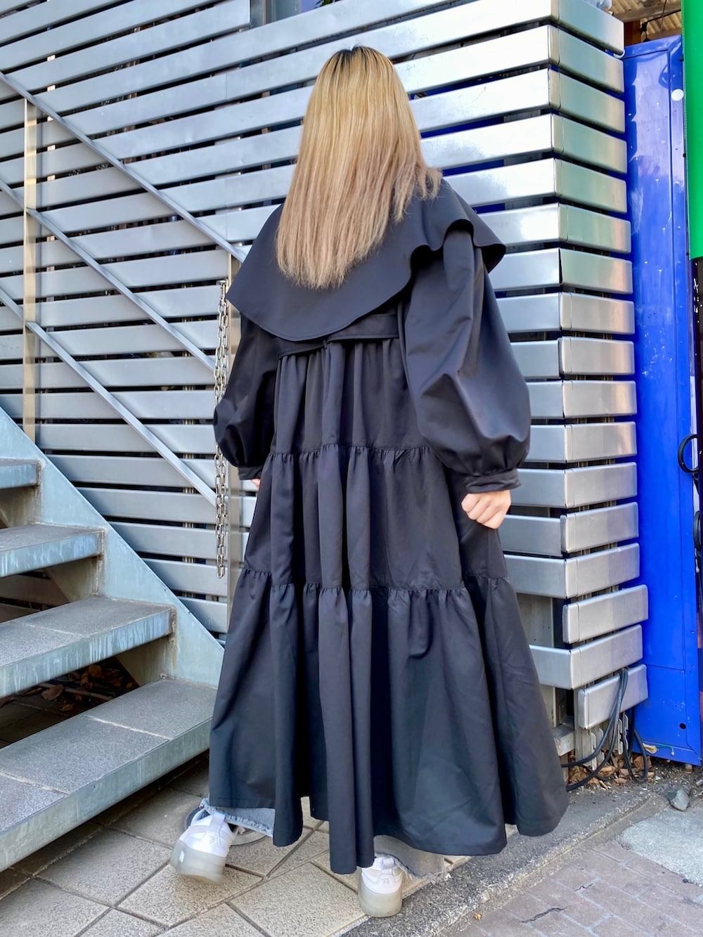 ブルー系のデニムパンツ、ブラック系のトレンチコート、グレー系のTシャツ/カットソーを着用したレディースの冬コーディネートの2枚目の写真