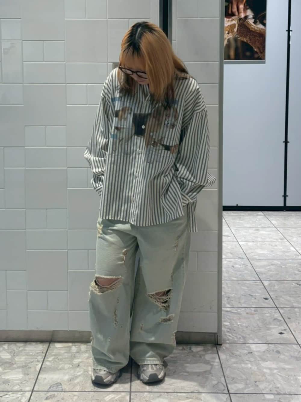 グレー系のシャツ/ブラウス、ブルー系のデニムパンツを着用したレディースの春コーディネートの2枚目の写真