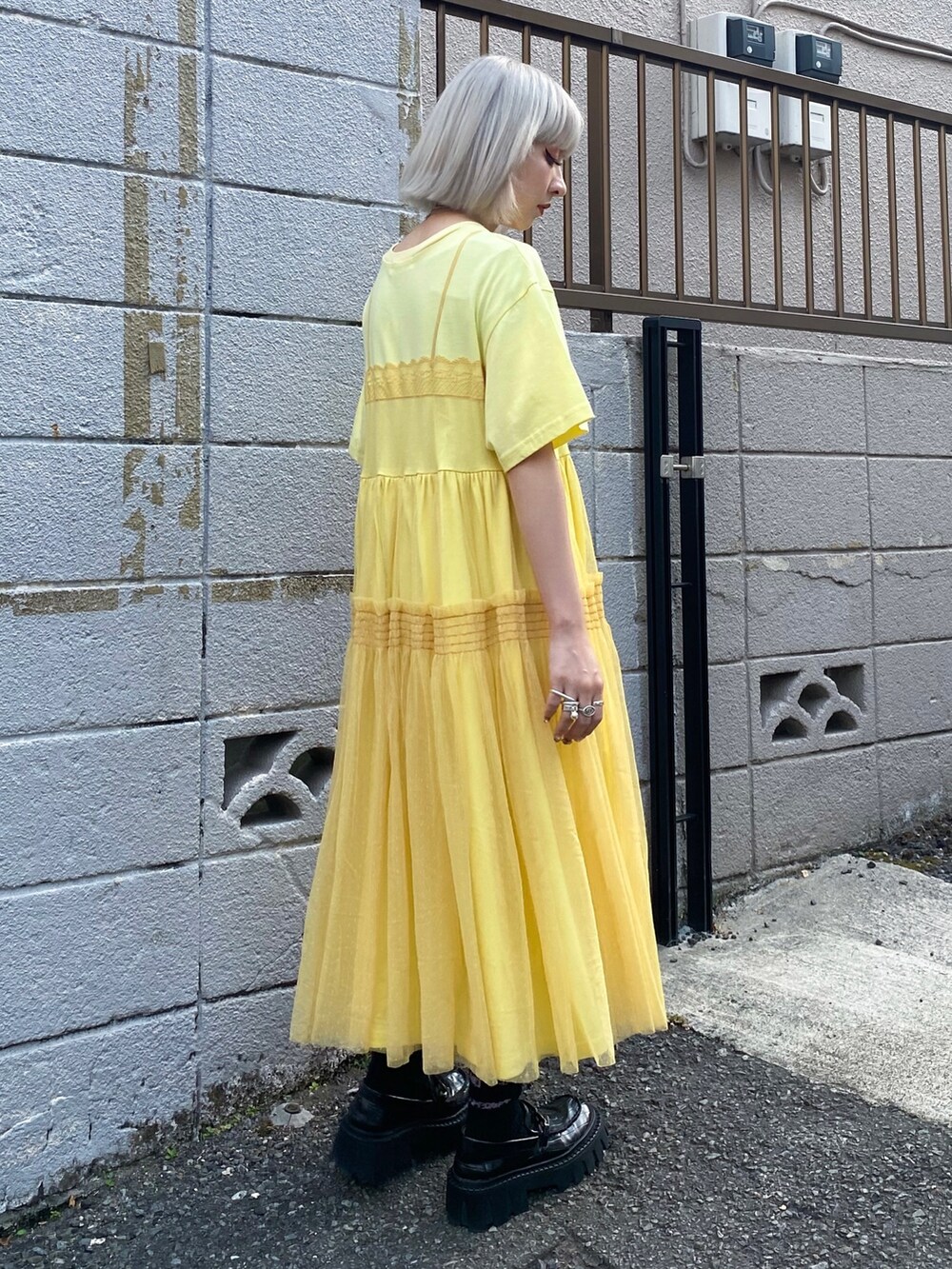 イエロー系のワンピース、ブラック系のローファーを着用したレディースの夏コーディネートの3枚目の写真