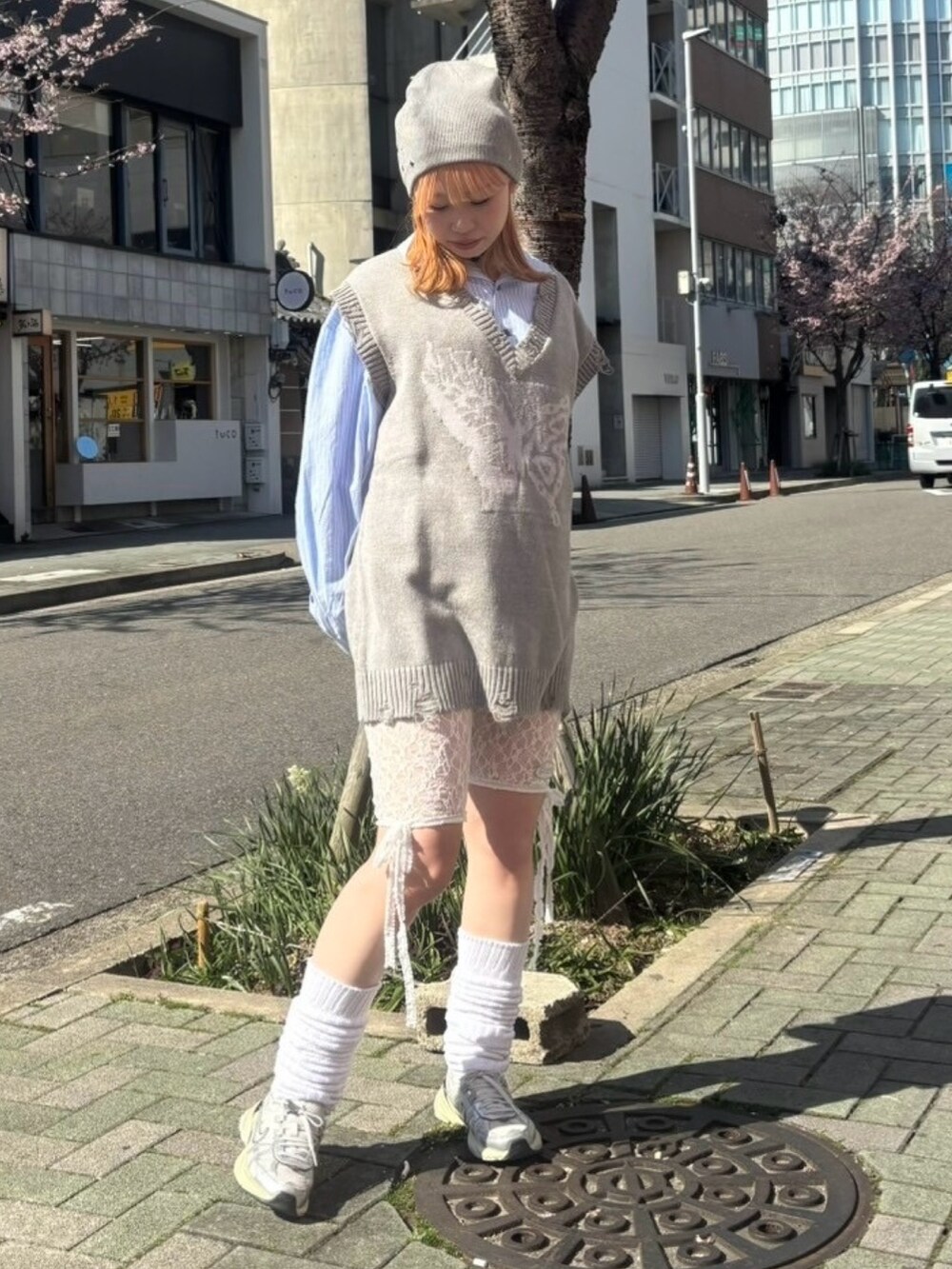 グレー系のベスト、ブルー系のシャツ/ブラウス、ホワイト系のその他パンツを着用したレディースの春コーディネートの2枚目の写真