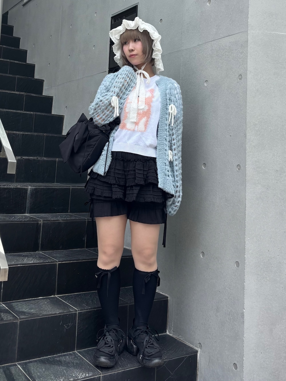 ブルー系のカーディガン/ボレロ、ホワイト系のニット/セーター、ブラック系のその他パンツを着用したレディースの夏コーディネートの5枚目の写真