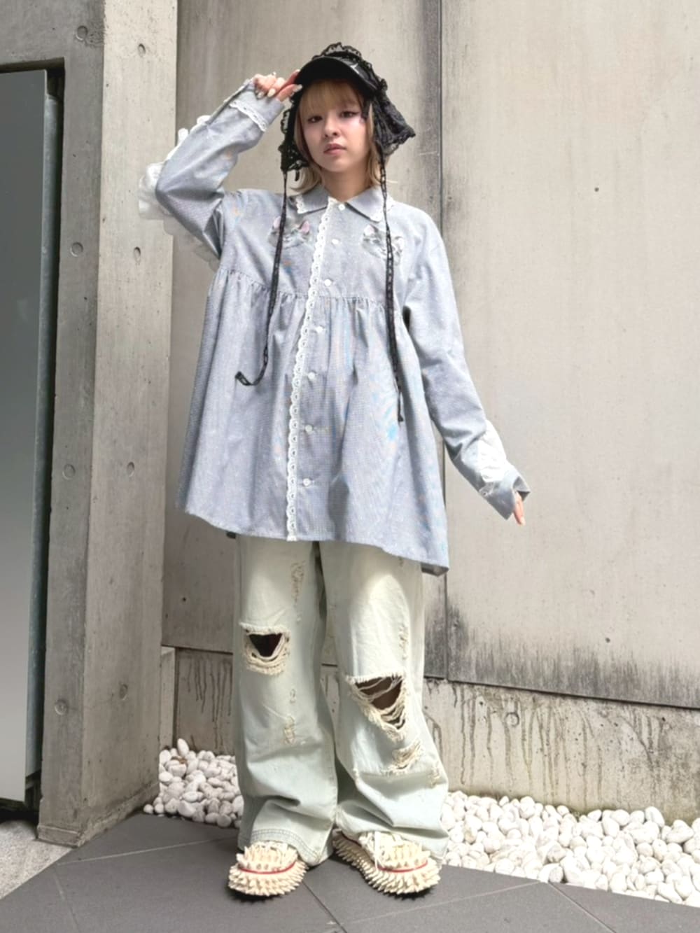 ブルー系のデニムパンツ、ブラック系のシャツワンピース、ブラック系のキャップを着用したレディースの春コーディネートの3枚目の写真