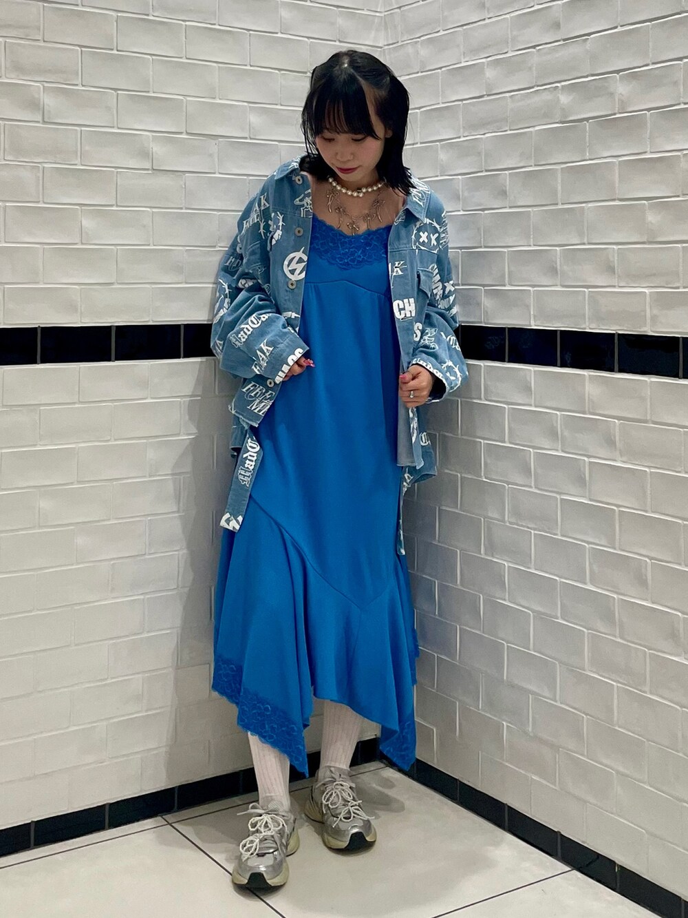 シルバー系のシューズ、ブルー系のワンピース、ブルー系のデニムジャケットを着用したレディースの夏コーディネートの2枚目の写真