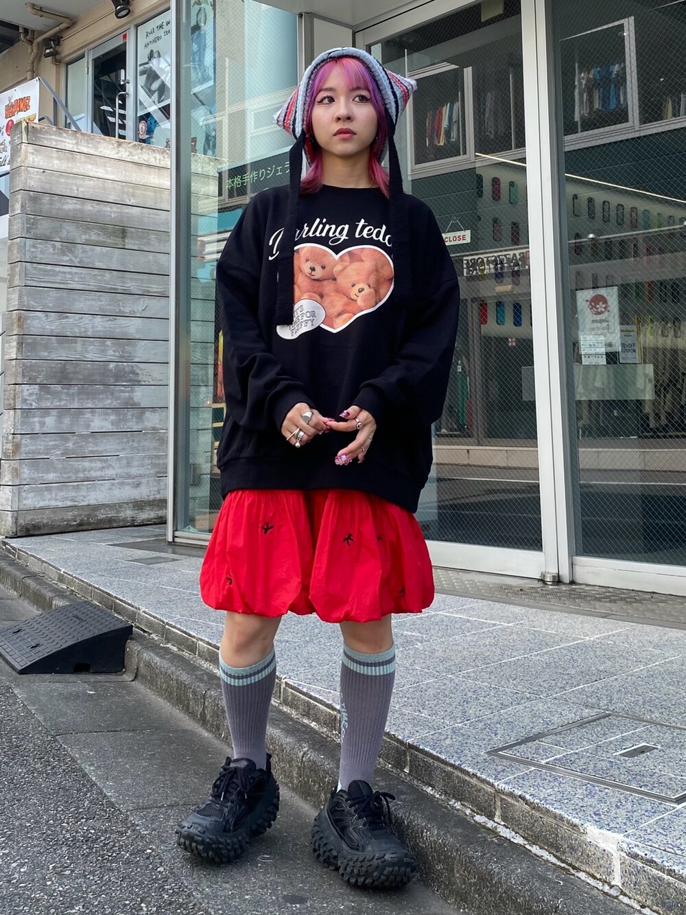 ブラック系のスウェット、レッド系のスカート、ブラック系のニットキャップ/ビーニーを着用したレディースの秋コーディネートの2枚目の写真