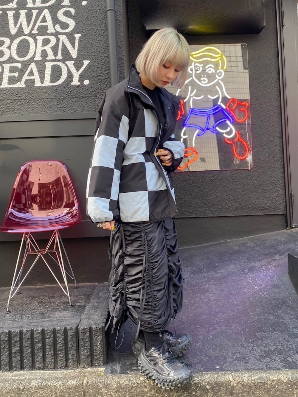 ブラック系のスカート、ブラック系のダウンジャケット/コート、ブラック系のTシャツ/カットソーを着用したレディースの秋コーディネートの3枚目の写真