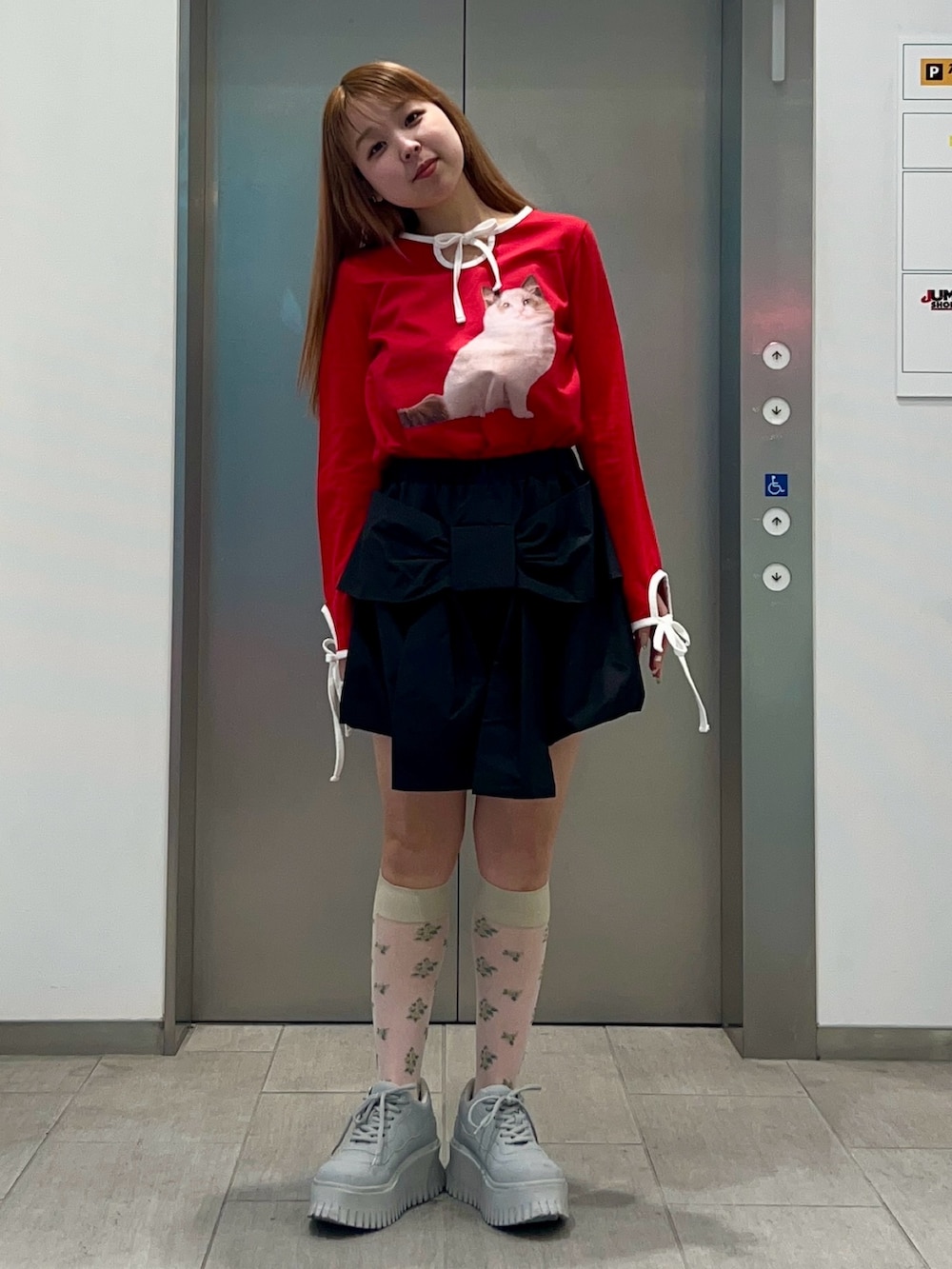 レッド系のスカート、ブラック系のその他パンツ、レッド系のTシャツ/カットソーを着用したレディースの冬コーディネートの5枚目の写真