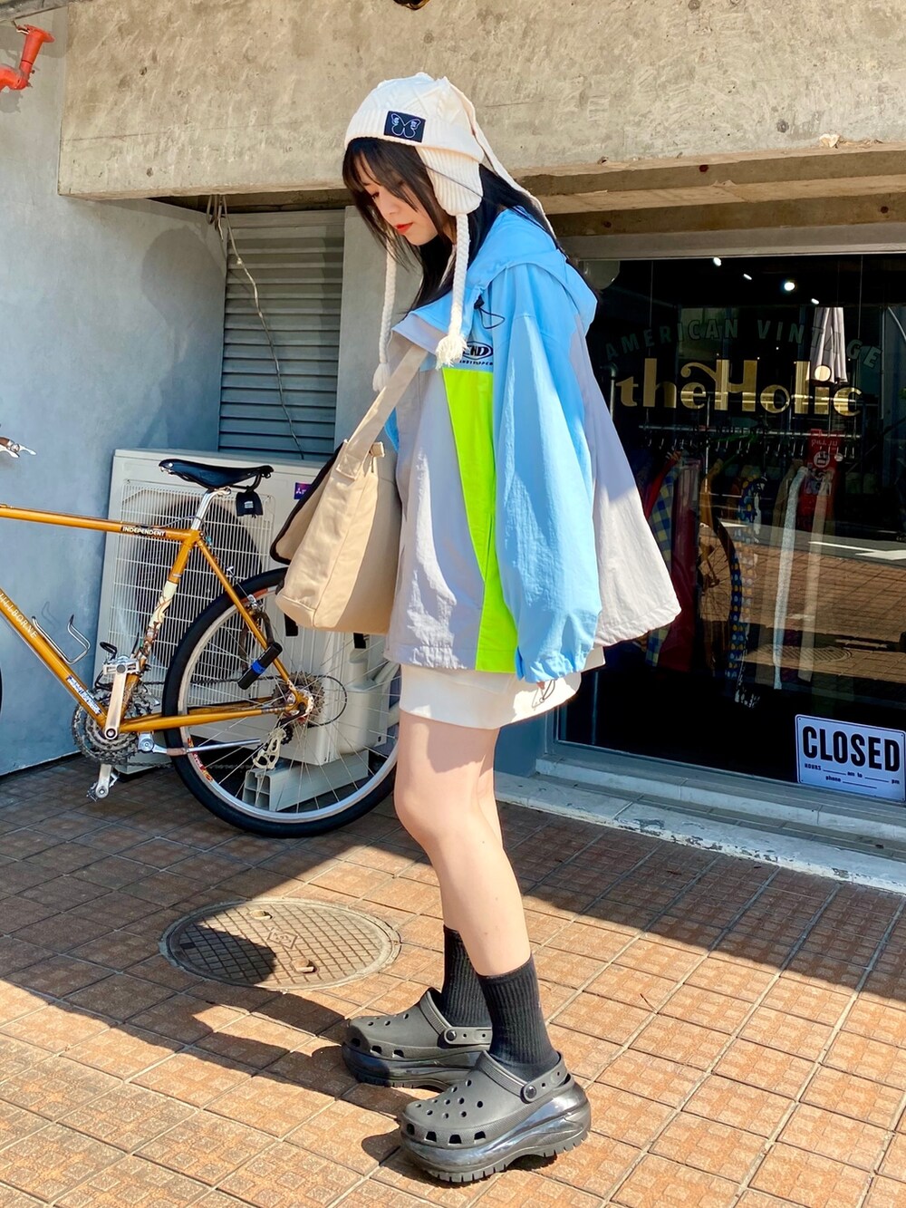 ブルー系のナイロンジャケット、ホワイト系のスウェット、ベージュ系のショルダーバッグを着用したレディースの秋コーディネートの3枚目の写真